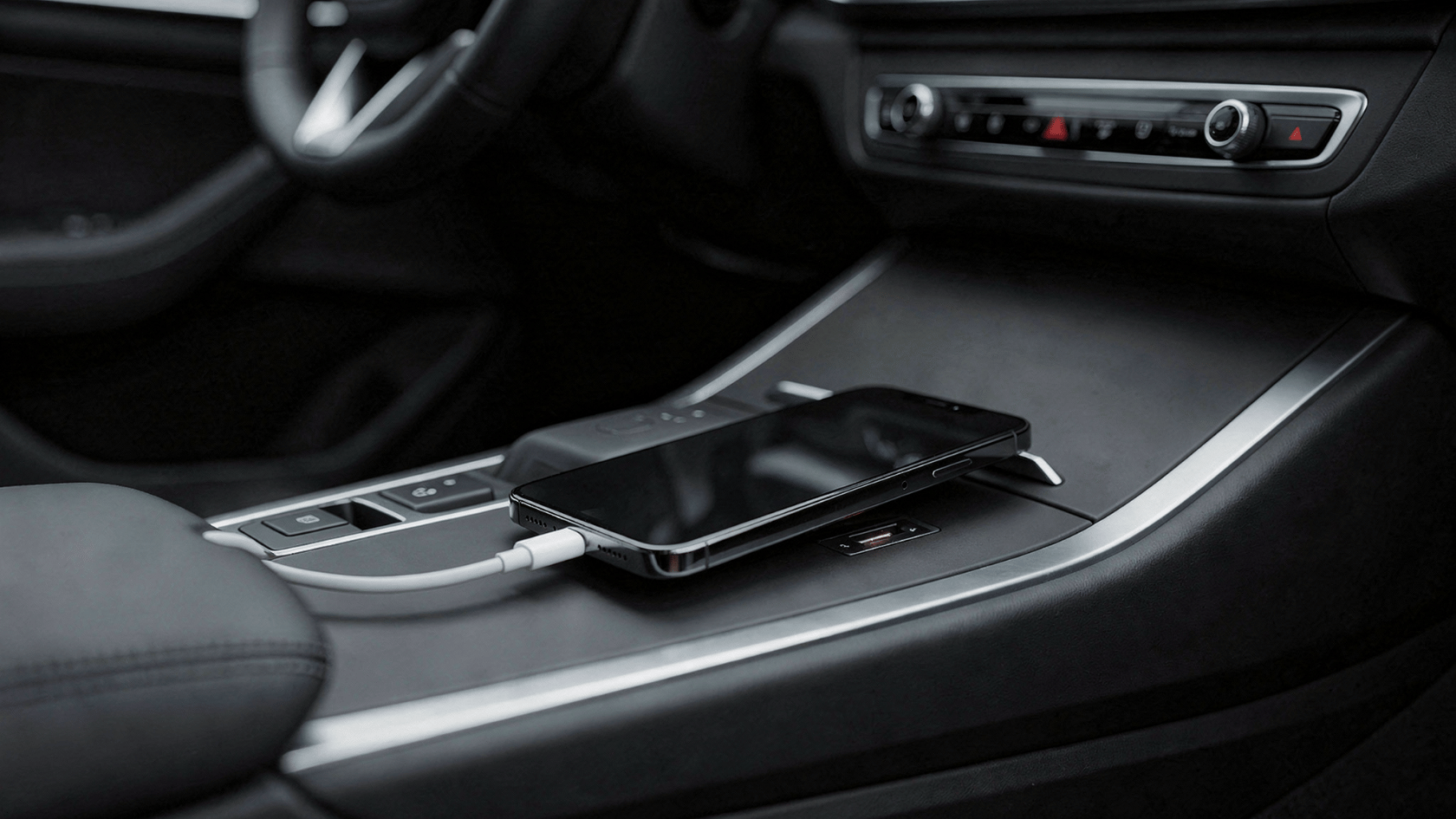 iPhone connected by cable to car USB port in center console close-up view