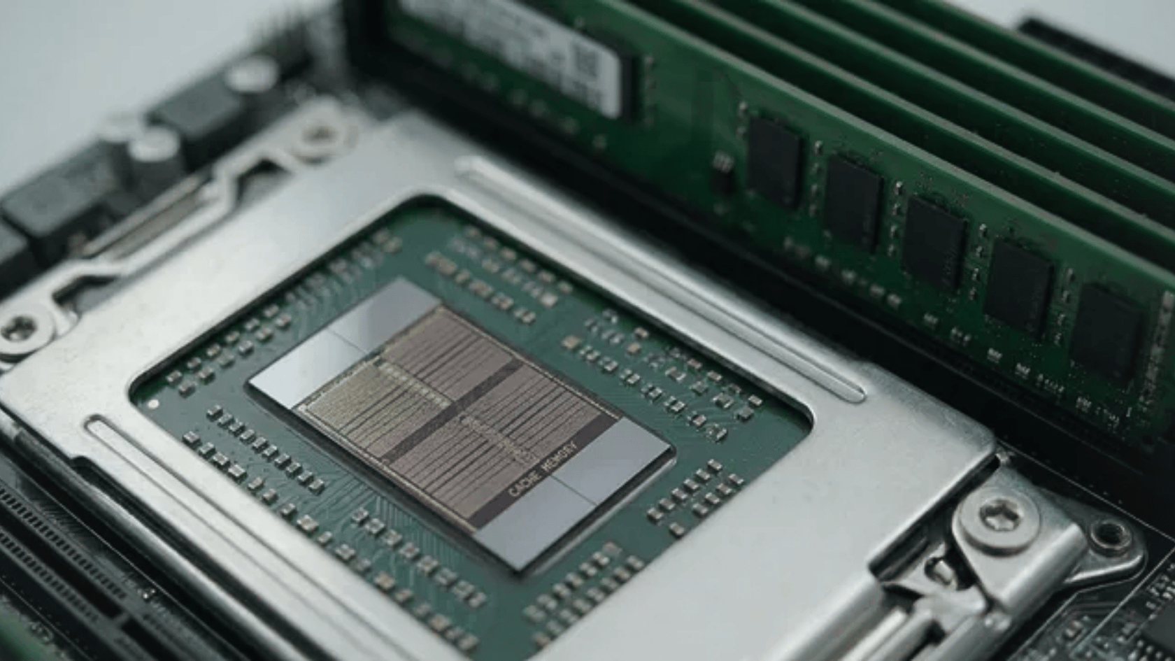 Close-up of a CPU showing its small cache area with RAM modules in the background on a motherboard.