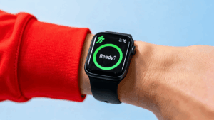 Apple Watch on a wrist displaying the Workout app start screen with a green activity ring.