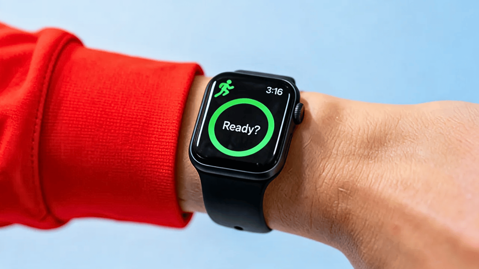 Apple Watch on a wrist displaying the Workout app start screen with a green activity ring.