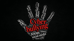 Cyberbullying word cloud with online safety and social media related terms on a black background.