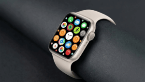 Starlight Apple Watch with matching band on grey background, displaying colorful app grid screen.